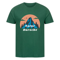 Das Premium-Shirt "Natur Bursche" von MarketPrint ist ein grünes Unisex-Biobaumwoll-T-Shirt mit Berg, Bäumen, Vögeln und einem orangefarbenen Kreismuster sowie dem Schriftzug "Natur Bursche" in Weiß und Blau - ideal für Fans nachhaltiger Mode.