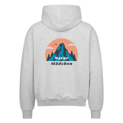 Der Oversized Zipper Hoodie "Natur" von MarketPrint in grau zeigt auf der Rückseite einen blauen Berg, Bäume, zwei Vögel und eine orangefarbene Sonne über "Natur Mädchen". Hergestellt aus 100% Baumwolle für Komfort.