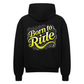 Der Oversized Zipper Hoodie "Born to Ride" von MarketPrint hat einen auffälligen gelben und weißen Schriftzug mit dekorativen Wirbeln auf dem Rücken, eine schwarze Oversized-Passform und ist aus 100% Baumwolle für ultimativen Komfort gefertigt.