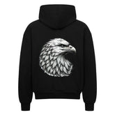 Der Oversized Zipper Hoodie "Adler" von MarketPrint ist ein schwarzer Premium-Kapuzenpulli in Oversized-Passform, der auf dem Rücken eine detailreiche weiß-graue Adlerkopf-Illustration groß aufgedruckt hat.