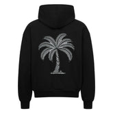 Der MarketPrint Oversized Zipper Hoodie "Palme" ist ein schwarzer Kapuzenpullover aus 100% Baumwolle mit einer weißen stilisierten Palmengrafik auf dem Rücken, die auf einem einfarbig weißen Hintergrund abgebildet ist.
