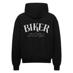 Der MarketPrint Oversized Zipper Hoodie "BIKER" in schwarz hat einen auffälligen weißen "BIKER LIFESTYLE"-Schriftzug auf dem Rücken, 100% Baumwolle und einen übergroßen Schnitt, der auf einem klaren weißen Hintergrund dargestellt ist.