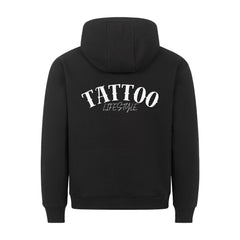 Der MarketPrint Premium Hoodie "TATTOO" ist ein schwarzes Sweatshirt aus der Türkei mit einer Kapuze mit Kordelzug und einem auffälligen Bogen- und Schriftdruck "TATTOO LIFESTYLE" auf dem Rücken.