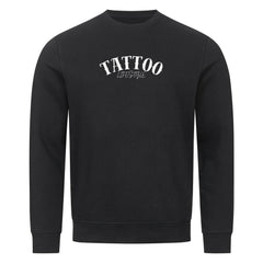 Das MarketPrint Premium Sweatshirt "TATTOO" ist ein schwarzer Unisex-Pullover aus Bio-Baumwolle mit dem geschwungenen weißen Schriftzug "TATTOO LIFESTYLE" - perfekt für Fans von nachhaltiger Mode.