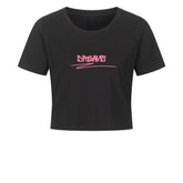 Das MarketPrint Ladies Cropped "DREAMS" ist ein schwarzes, kurz geschnittenes Damen-Shirt aus Baumwolle mit kurzen Ärmeln und pinkem Graffiti-Schriftzug "DREAMS" auf der Brust.