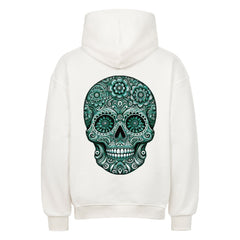 Der Oversized Hoodie "Totenkopf" von MarketPrint ist aus schwerer weißer Baumwolle gefertigt und zeigt einen detaillierten grünen Zuckerschädel mit Blumen- und Wirbelmustern auf der Rückseite. Premium-Qualität, rückseitig ausgestellt.