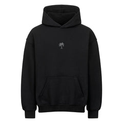 Der MarketPrint Oversized Hoodie "Sonnenuntergang" ist ein schlichter schwarzer Kapuzenpullover mit einer Fronttasche und einer kleinen, schlichten Palmengrafik mittig auf der Brust.