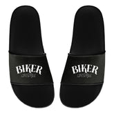 Ein Paar schwarze MarketPrint Badelatschen "Biker" mit weißem Schriftzug "BIKER LIFESTYLE" auf den Riemen, nebeneinander gestellt, mit der Vorderseite nach oben - perfekt für Ihren nächsten Badetag.