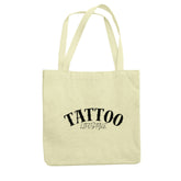 Der Jutebeutel "Tattoo" von MarketPrint ist beige, besteht aus recycelter Baumwolle, hat lange Henkel und zeigt in schwarzer Schrift TATTOO LIFESTYLE auf der Vorderseite.
