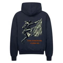 Der MarketPrint Oversized Zipper Hoodie "Find strength, climb on." in schwarz besteht aus 100% Baumwolle und zeigt eine Klettergrafik mit fetter, orangefarbener Schrift unter der Illustration.