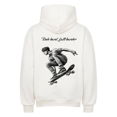 Der MarketPrint Oversized Hoodie "Ride Hard" ist weiß und zeigt eine schwarz-weiße Skateboard-Illustration mit dem Text "Ride hard, fall harder" über dem Bild auf dem Rücken.