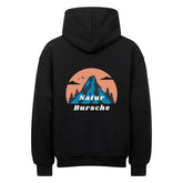Der MarketPrint Oversized Hoodie "Natur Bursche" zeigt eine Rückengrafik mit einem blauen Berg, Bäumen und Vögeln vor einem orangefarbenen Kreis, darunter steht in weißer Schrift "Natur Bursche".