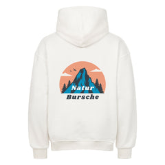 Der Oversized Hoodie "Natur Bursche" von MarketPrint ist ein weißer Premium-Kapuzenpulli mit einer Rückengrafik von einem blauen Berg, Bäumen, Vögeln, einem orangefarbenen Himmel und "Natur Bursche" darunter in blau und weiß gedruckt.