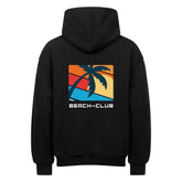 Der MarketPrint Oversized Hoodie "Beach-club" ist ein schwarzer Kapuzenpullover mit der Rückengrafik einer Palmensilhouette über einem Retro-Sonnenuntergang und dem Text BEACH-CLUB darunter.
