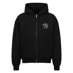 Der MarketPrint Oversized Zipper Hoodie "Tiger" ist schwarz, 100% Baumwolle, mit einer Fronttasche, Kapuze mit Kordelzug, Rippbündchen an Ärmeln und Saum und einem kleinen gestickten brüllenden Tigerkopf auf der linken Brust. Verfügt über einen übergroßen Schnitt.