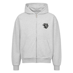 Der Oversized Zipper Hoodie "Tiger" von MarketPrint ist hellgrau, aus 100% Baumwolle im Oversized-Schnitt, mit Fronttasche, Kapuze mit Kordelzug, Rippbündchen an Ärmeln und Saum und einem kleinen gestickten schwarzen Tigerkopf auf der linken Brust.