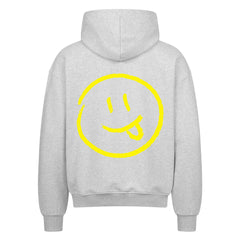 Der MarketPrint Oversized Zipper Hoodie "Smiley" kommt in Hellgrau, zeigt ein großes gelbes Smiley-Gesicht mit herausgestreckter Zunge auf dem Rücken und ist aus 100% Baumwolle für hervorragenden Komfort und Stil gefertigt.