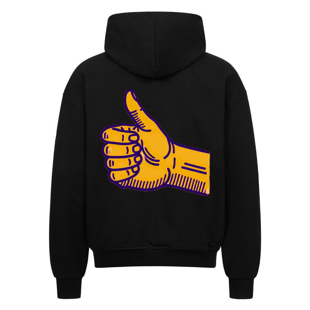 Der Oversized Zipper Hoodie "Daum hoch" von MarketPrint ist ein schwarzer Kapuzenpulli mit einer großen gelben Daumen-hoch-Grafik auf dem Rücken, die lila umrandet ist.