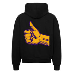 Der Oversized Zipper Hoodie "Daum hoch" von MarketPrint ist ein schwarzer Kapuzenpulli mit einer großen gelben Daumen-hoch-Grafik auf dem Rücken, die lila umrandet ist.