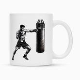 Die Tasse "Boxer" von MarketPrint ist eine weiße Keramiktasse mit schwarz-weißer Boxer-Illustration und strapazierfähiger Duraglaze-Beschichtung für brillante, langanhaltende Farben.