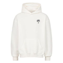 Der Infinity Merch Oversized Hoodie "Strand" ist ein hochwertiger weißer Kapuzenpulli mit lockerer Passform, Vordertasche, gerippten Bündchen und einer kleinen schwarzen Palmengrafik auf der linken Brust für den täglichen Komfort.