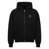 Der Oversized Zipper Hoodie "Strand" von Infinity Merch ist ein schwarzer Premium-Kapuzenpullover mit einer Fronttasche und einer kleinen Palmengrafik auf der linken Brust. Er besteht aus 100% Baumwolle und ist auf weißem Hintergrund abgebildet.
