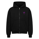 Der Infinity Merch Oversized Zipper Hoodie "Strand" ist schwarz und hat eine Kapuze, Vordertaschen und eine kleine lila Palmengrafik auf der linken Brust. Er ist aus 100% Baumwolle in einem übergroßen Schnitt gefertigt und erscheint vor einem schlichten weißen Hintergrund.