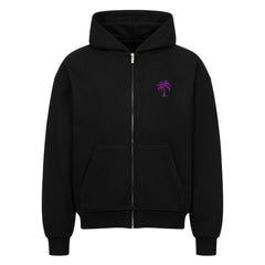 Der Infinity Merch Oversized Zipper Hoodie "Strand" ist schwarz und hat eine Kapuze, Vordertaschen und eine kleine lila Palmengrafik auf der linken Brust. Er ist aus 100% Baumwolle in einem übergroßen Schnitt gefertigt und erscheint vor einem schlichten weißen Hintergrund.