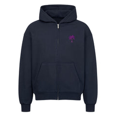Der Infinity Merch Oversized Zipper Hoodie "Strand" ist ein dunkelblauer Hoodie aus 100% Baumwolle mit übergroßer Passform, Kapuze, Vordertaschen und einer kleinen lila Palme auf der linken Brust, abgebildet auf weißem Hintergrund.