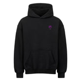 Der Infinity Merch Oversized Hoodie "Strand" ist ein schwarzer Hoodie mit einer Fronttasche und einer kleinen lila Palmengrafik auf der linken Brust.