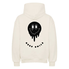 Der MarketPrint Oversized Hoodie "Keep Smile" ist cremefarben mit einem schwarzen, tropfenden Smiley-Gesicht und dem Schriftzug KEEP SMILE in schwarzer Schrift unter der Grafik auf dem Rücken.