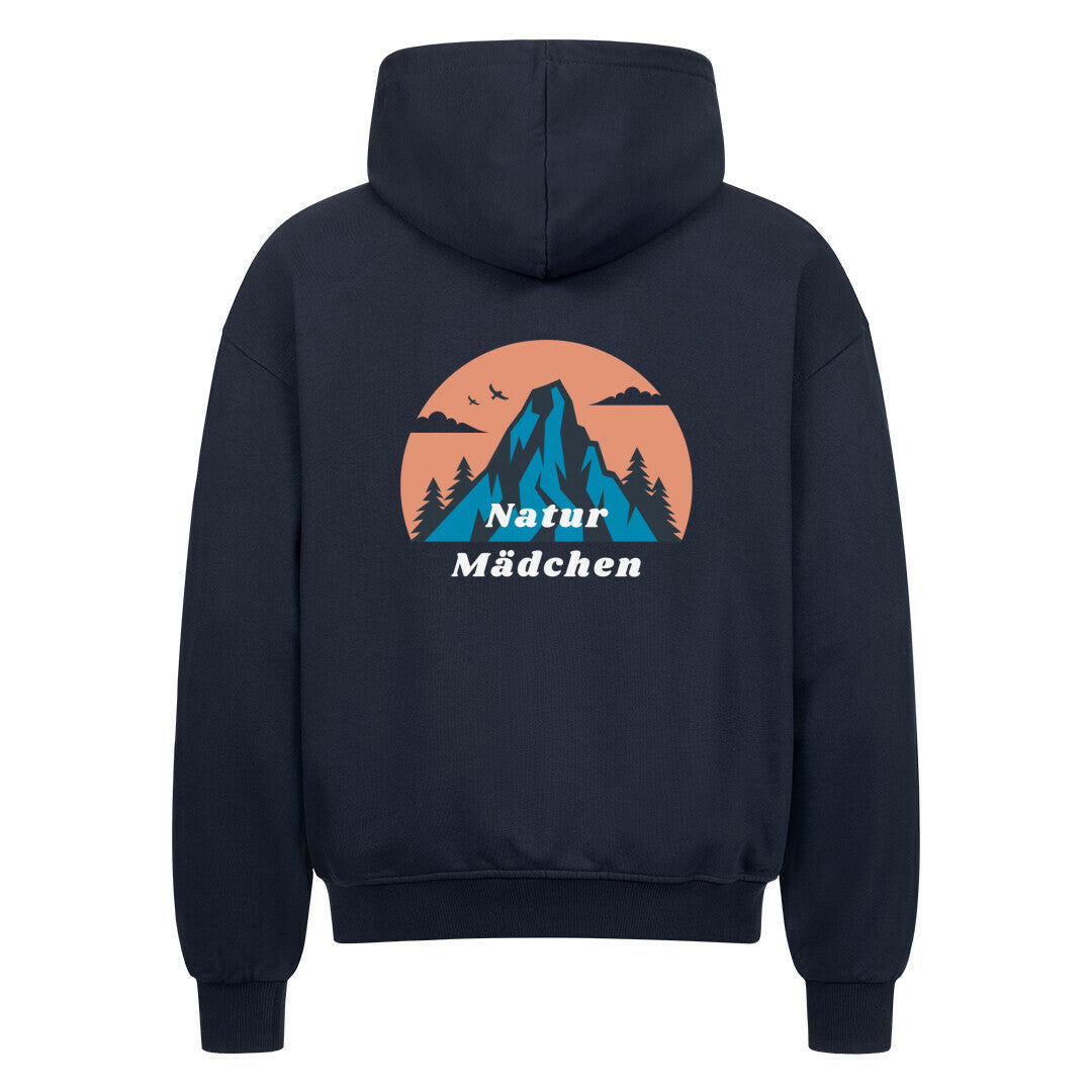 Der Oversized Zipper Hoodie "Natur" von MarketPrint ist marineblau mit einer Berg-, Baum- und Vogelgrafik in einem orangefarbenen Kreis auf dem Rücken. Darunter steht "Natur Mädchen" in weiß. Hergestellt aus 100% Baumwolle.