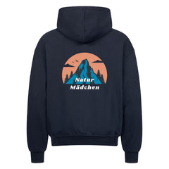 Der Oversized Zipper Hoodie "Natur" von MarketPrint ist marineblau mit einer Berg-, Baum- und Vogelgrafik in einem orangefarbenen Kreis auf dem Rücken. Darunter steht "Natur Mädchen" in weiß. Hergestellt aus 100% Baumwolle.