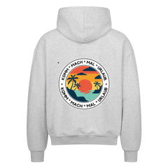 Der Oversized Zipper Hoodie "Urlaub" von MarketPrint hat eine graue, lockere Passform mit einer Sonnenuntergangs-, Palmen- und Meeresgrafik sowie KOMM * MACH * MAL * URLAUB Text auf dem Rücken. Hergestellt aus 100% Baumwolle für erstklassigen Komfort.