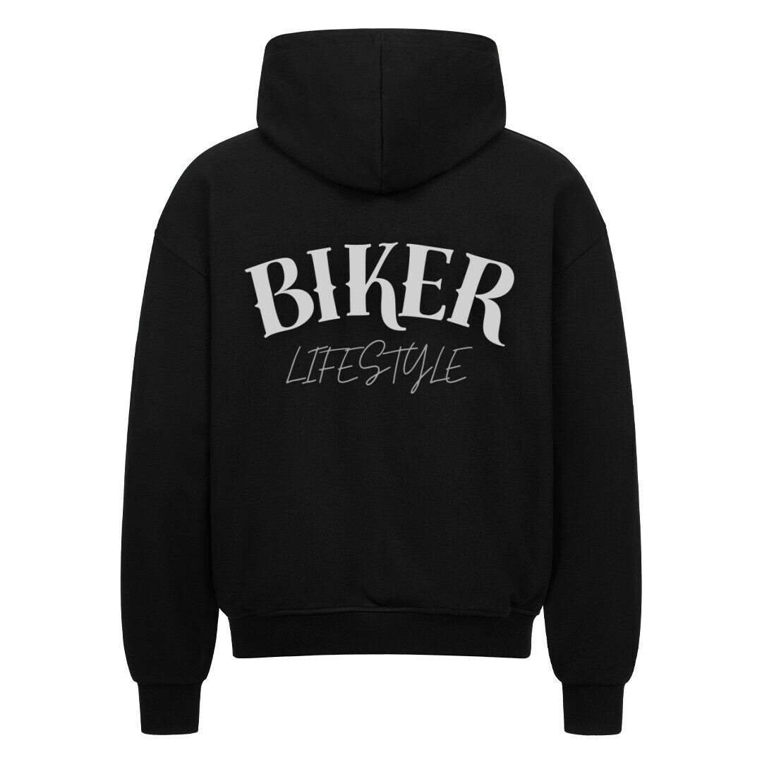 Der MarketPrint Oversized Zipper Hoodie "BIKER" in schwarz hat einen auffälligen weißen "BIKER LIFESTYLE"-Schriftzug auf dem Rücken, 100% Baumwolle und einen übergroßen Schnitt, der auf einem klaren weißen Hintergrund dargestellt ist.