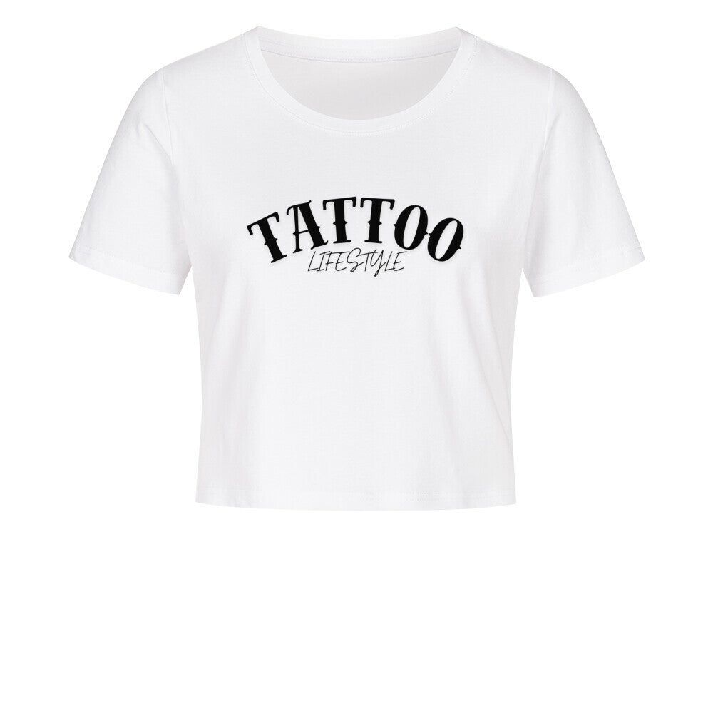 Das MarketPrint Ladies Cropped "Tattoo" Shirt ist ein weißes, kurz geschnittenes Damen-Shirt aus Baumwolle mit "TATTOO LIFESTYLE" in schwarzer Schrift vorne, präsentiert vor schlichtem weißen Hintergrund.