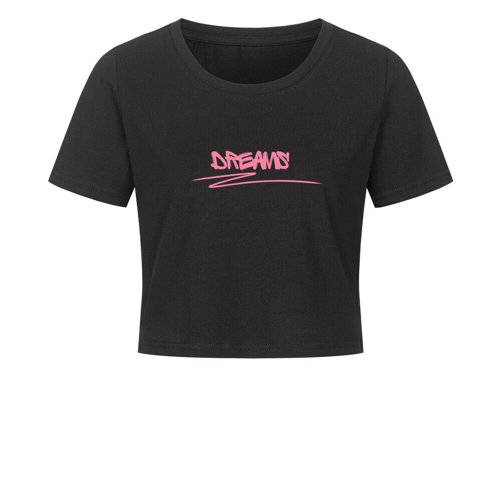Das MarketPrint Ladies Cropped "DREAMS" ist ein schwarzes, kurz geschnittenes Damen-Shirt aus Baumwolle mit kurzen Ärmeln und pinkem Graffiti-Schriftzug "DREAMS" auf der Brust.