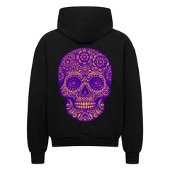 Der Oversized Zipper Hoodie "Totenkopf" von MarketPrint ist ein schwarzer Kapuzenpulli aus 100% Baumwolle mit einem verschnörkelten lila-goldenen Totenkopf-Motiv, das auf der Rückseite mit komplizierten Blumen- und Wirbelmustern versehen ist.