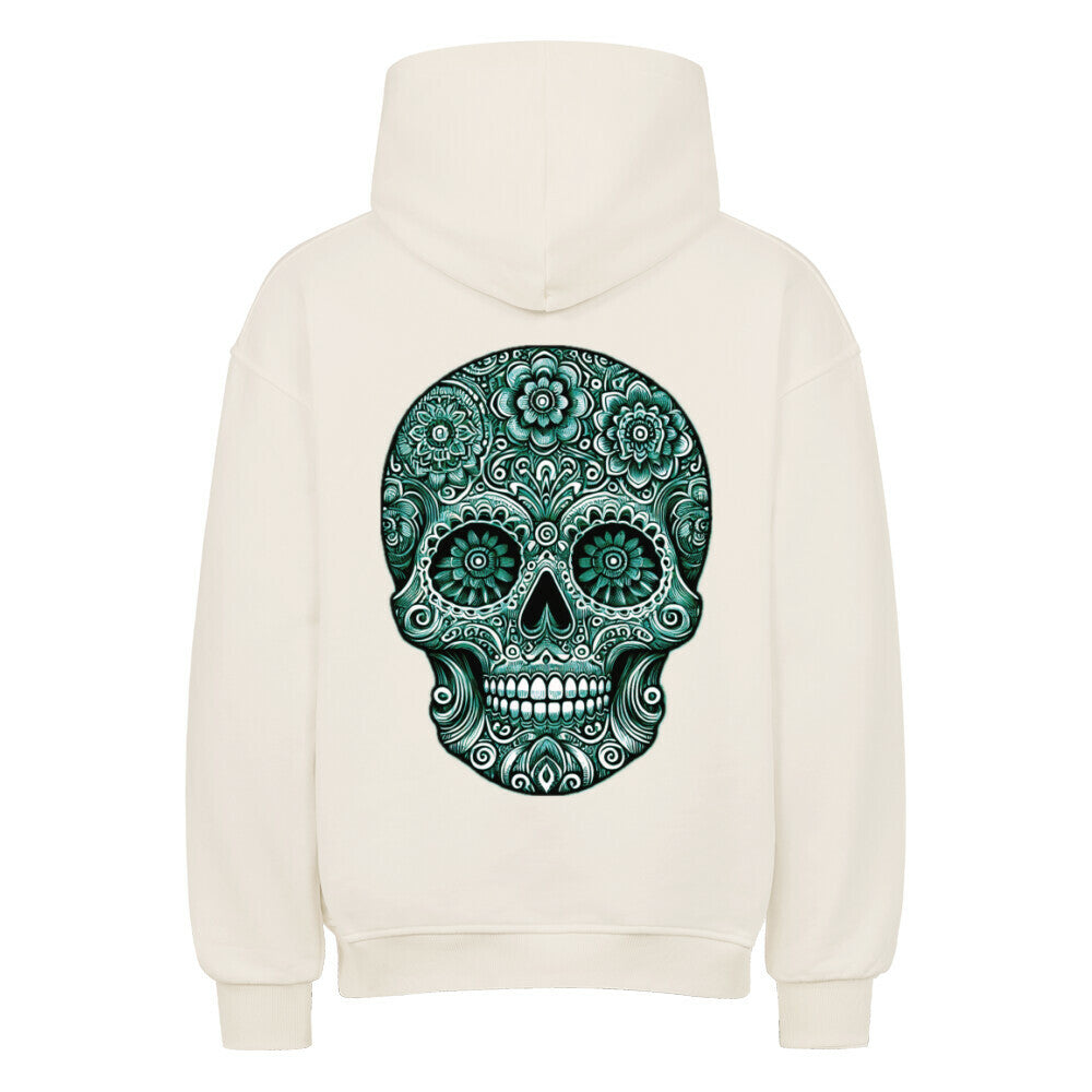 Der Oversized Hoodie "Totenkopf" von MarketPrint ist cremefarben, von hinten mit aufgesetzter Kapuze, und zeigt einen auffälligen grün-schwarzen Zuckerschädel mit Blumen- und Wirbelmustern, der seinen gemütlichen, hochwertigen Stil unterstreicht.