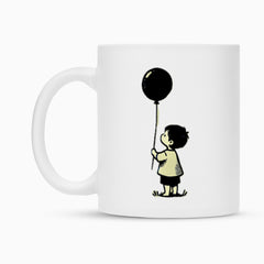 Die MarketPrint Tasse "Junge-Ballon" ist eine weiße Keramiktasse mit der Illustration eines kleinen Kindes im Gras, das einen schwarzen Luftballon hält und in die Höhe schaut.