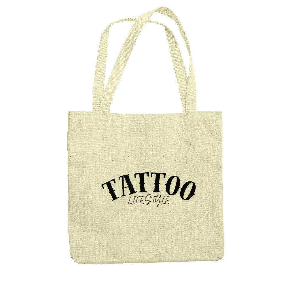 Der Jutebeutel "Tattoo" von MarketPrint ist beige, besteht aus recycelter Baumwolle, hat lange Henkel und zeigt in schwarzer Schrift TATTOO LIFESTYLE auf der Vorderseite.