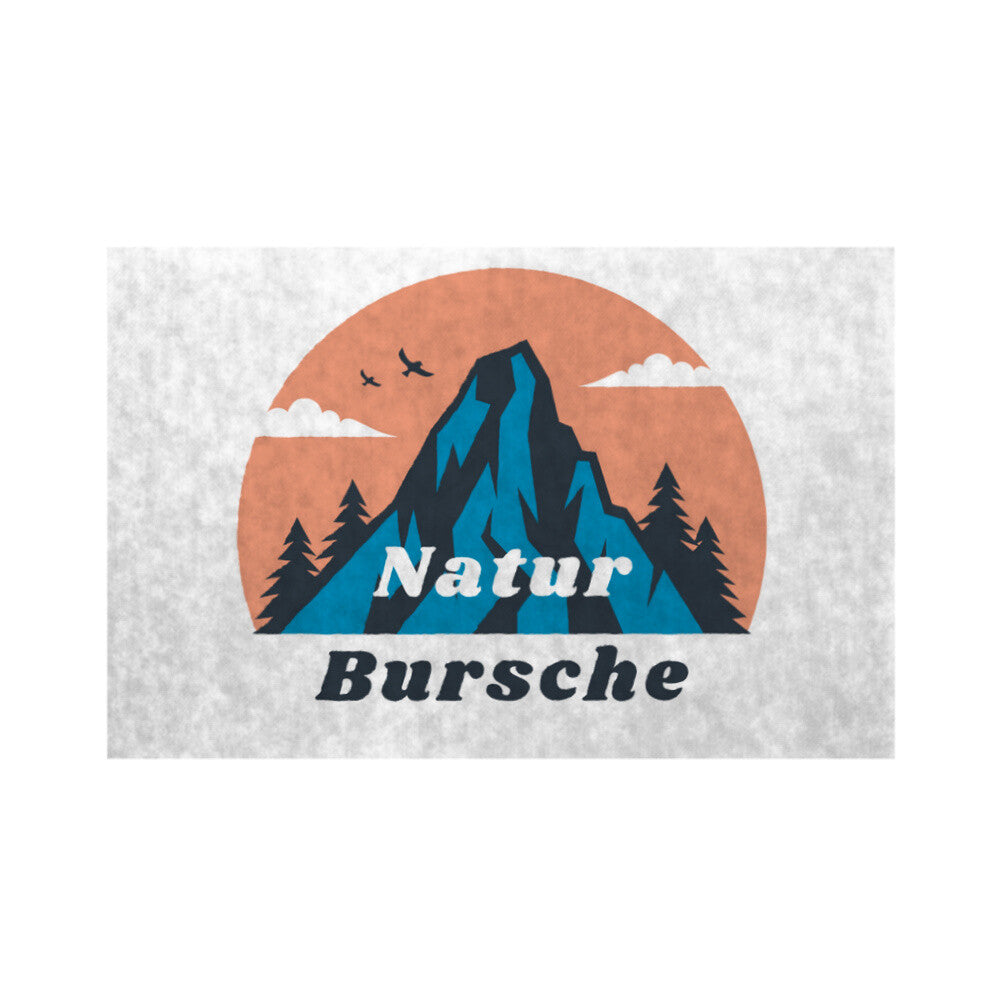 Die MarketPrint Fußmatte "Naturbursche" zeigt einen Berg mit Tannenbäumen, drei Vögeln und Wolken vor einer orangefarbenen Sonne. "Naturbursche" steht fett darunter auf dieser strapazierfähigen, schmutzabweisenden Matte.