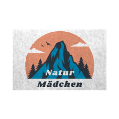 Illustration von einem Berg, Bäumen, zwei Vögeln und Wolken auf einem orangefarbenen Kreis mit "Natur Mädchen" in blau und schwarz. Die MarketPrint Fußmatte hält Schmutz abhalten und Ihren Eingangsbereich sauber.