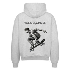 Der MarketPrint Oversized Zipper Hoodie "Fall hard, fall harder" hat ein graues Design mit einer schwarz-weißen Skateboarder-Grafik und dem Spruch darüber auf dem Rücken. Hergestellt aus 100% Baumwolle für erstklassigen Komfort.