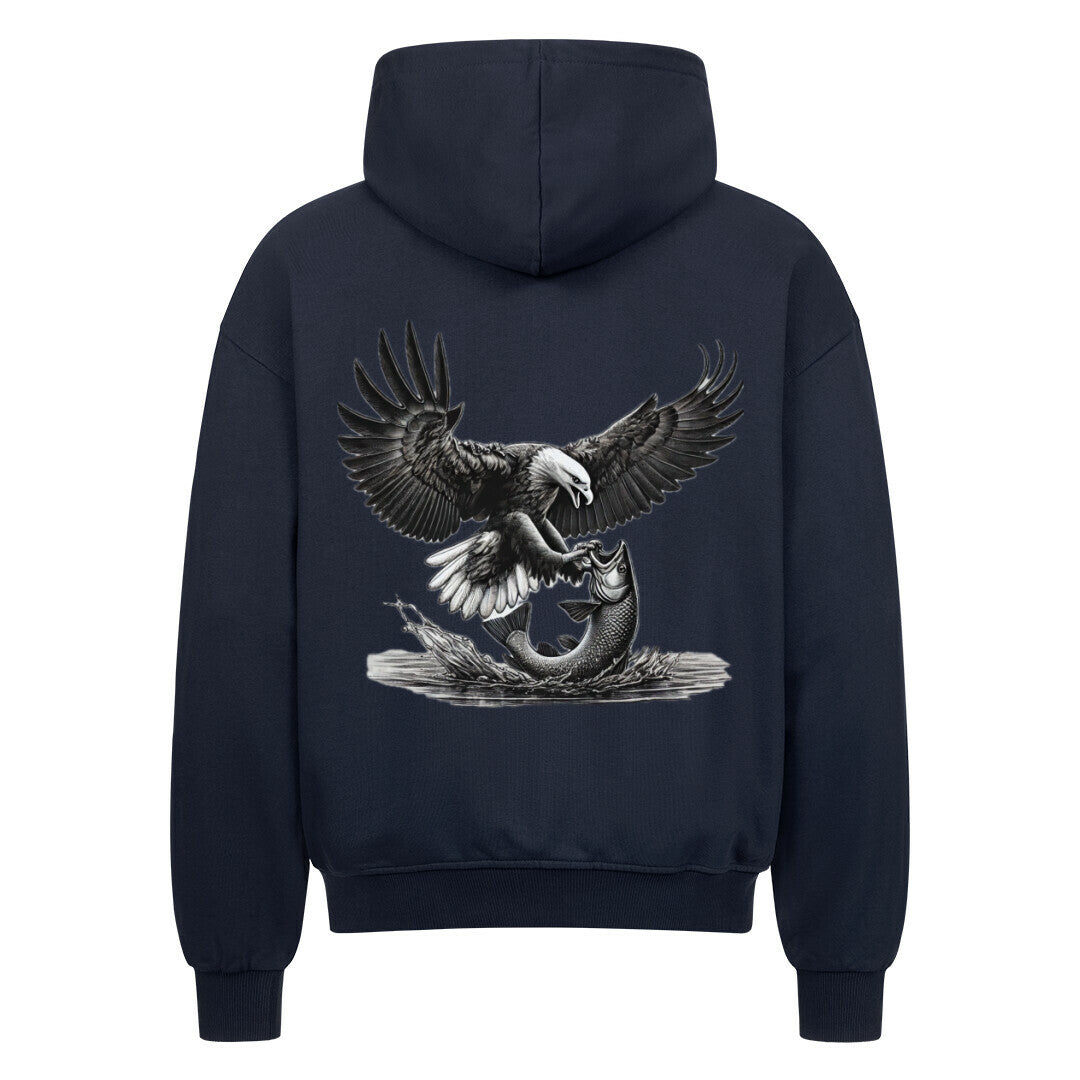 Der Oversized Zipper Hoodie "Adler-fisch" von MarketPrint ist ein navyblauer Premium-Kapuzenpulli, auf dessen Rückseite ein Adler abgebildet ist, der im Sturzflug einen Fisch fängt.