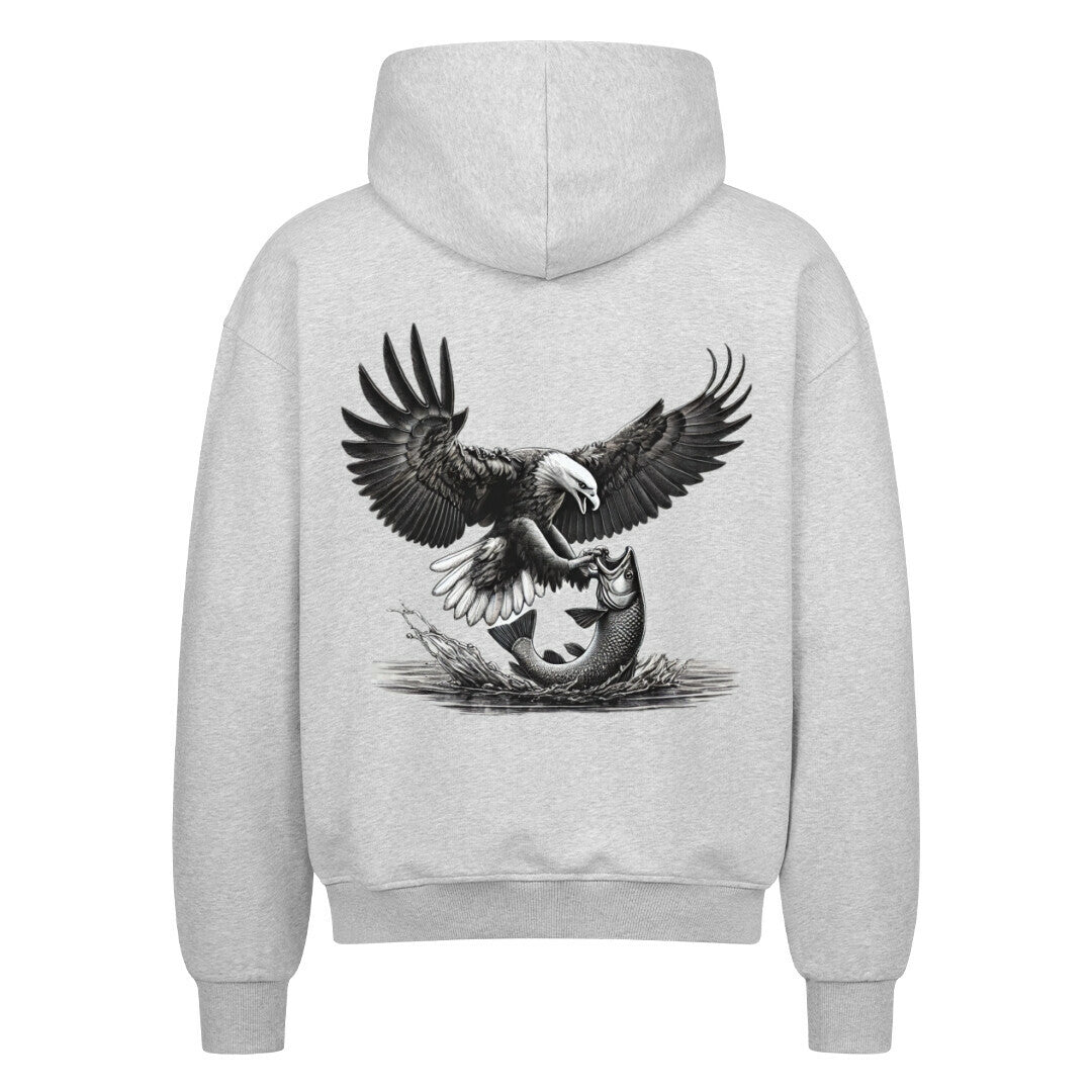 Der MarketPrint Oversized Zipper Hoodie "Adler-fisch" in Hellgrau zeigt auf der Rückseite eine detailreiche Adler-Grafik mit ausgebreiteten Flügeln, die einen Fisch über Wasser und Schilf umklammert.