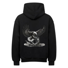 Der MarketPrint Oversized Hoodie "Adler-Fisch" ist ein schwarzer Kapuzenpulli aus schwerer Baumwolle mit einer auffälligen Rückengrafik, die einen Weißkopfseeadler zeigt, der sich mit ausgestreckten Krallen auf einen Fisch stürzt.
