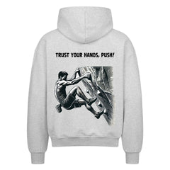 Der MarketPrint Oversized Zipper Hoodie "Bouldern" in Hellgrau zeigt einen Mann beim Klettern von hinten und den Text "TRUST YOUR HANDS, PUSH!" über der Abbildung.