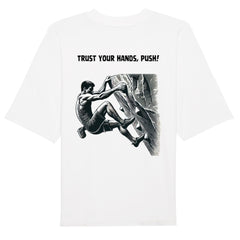 Das Premium Oversize Blast "Bouldern" T-Shirt von MarketPrint besteht aus Bio-Baumwolle, ist weiß und zeigt hinten eine schwarz-weiße Illustration einer kletternden Person mit dem Schriftzug "TRUST YOUR HANDS, PUSH!".