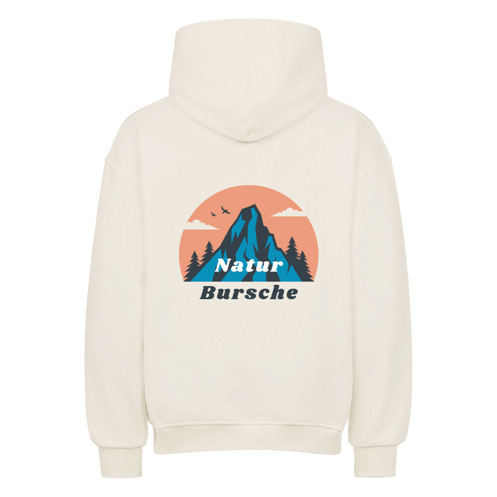 Der MarketPrint Oversized Hoodie "Natur Bursche" ist cremefarben und zeigt auf dem Rücken eine Berg-, Baum-, Vogel- und Wolkengrafik, darunter ist "Natur Bursche" in blau und weiß aufgedruckt.